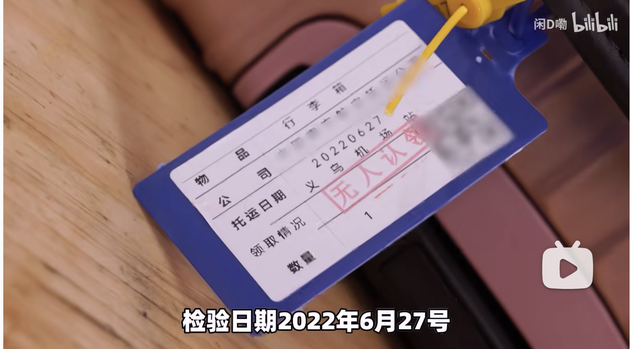 行李箱上挂有标牌，上面写着托运日期为2022年6月27日，来自义乌机场站。  视频截图