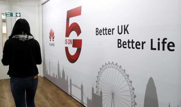 2020年1月，在英国伦敦，一名工作人员从华为5G创新体验中心走过。（新华社）