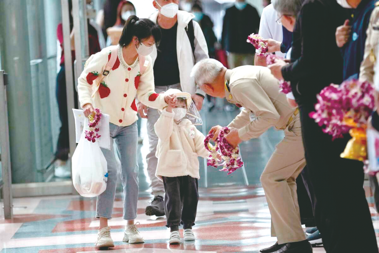     泰国政府高官在机场向到来的中国游客送花与纪念品