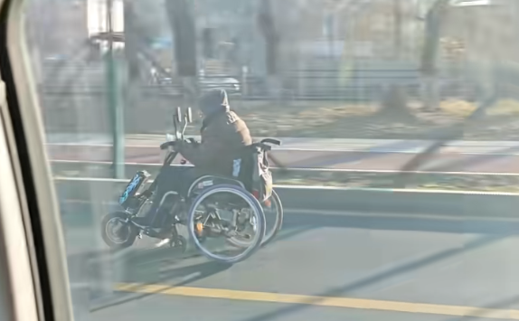 大爷坐轮椅快速路上狂飙：比汽车跑得都快